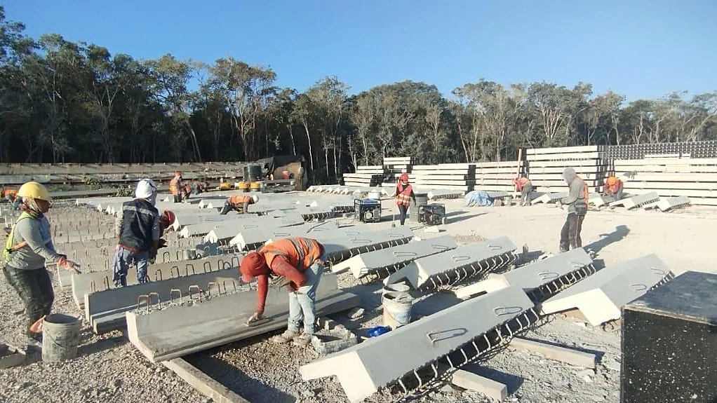 Patio de obra con elementos prefabricados de concreto y personal trabajando