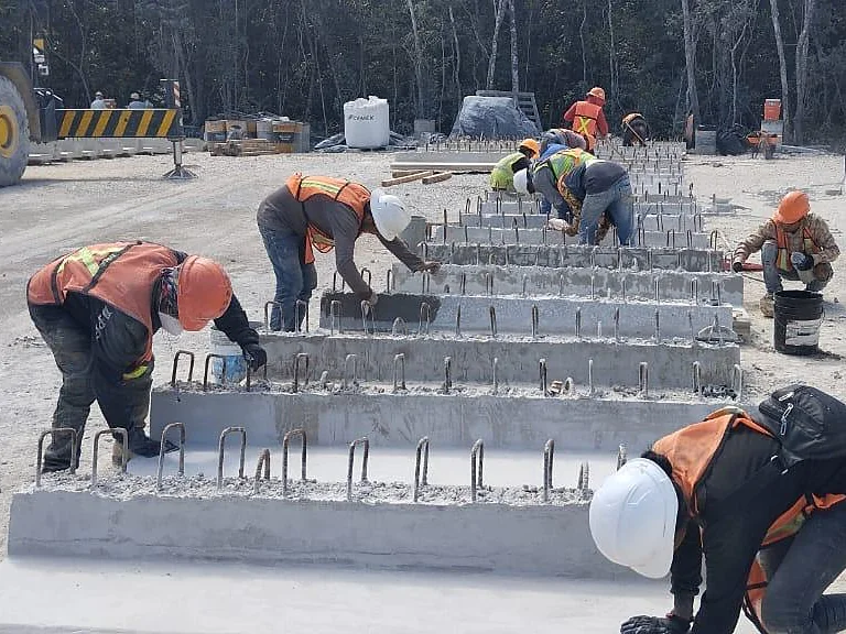 Personal en obra dando acabado a elementos prefabricados de concreto