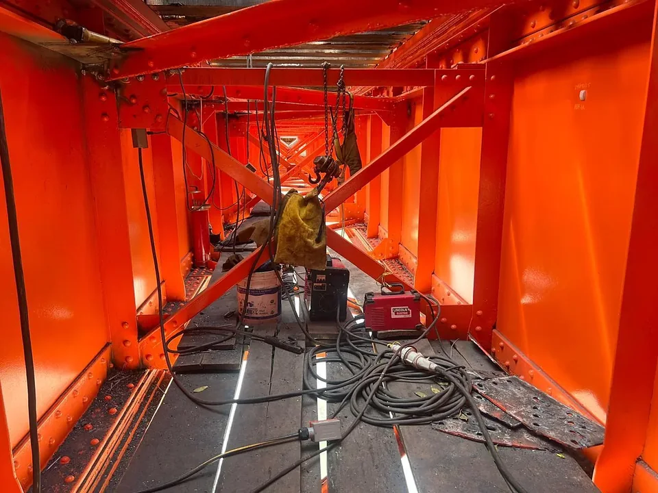 Interior de una estructura metálica rehabilitada y recién pintada, con equipo de soldadura